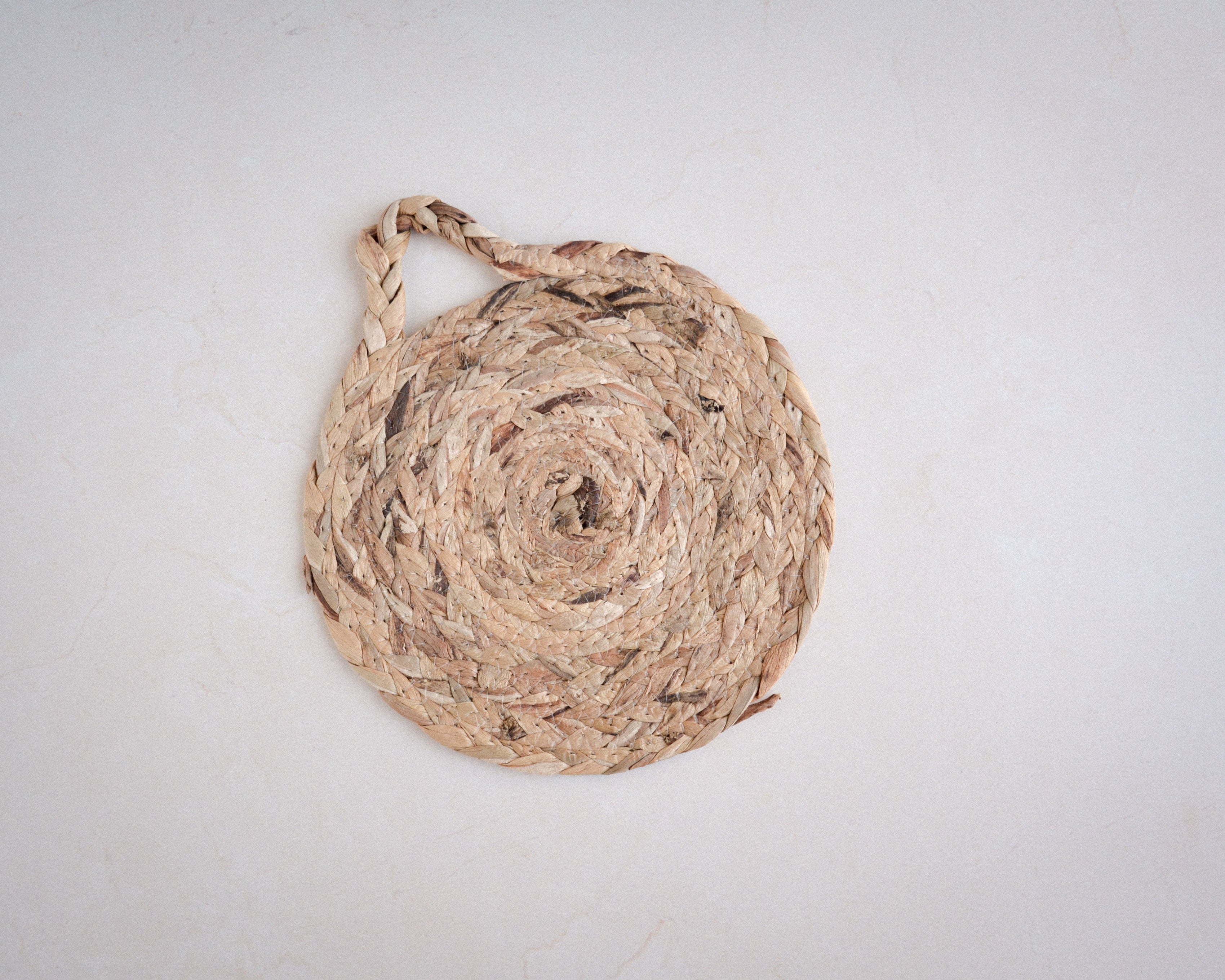Round woven natural trivet with handle